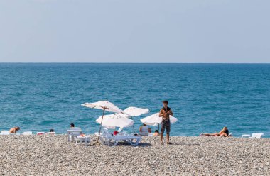 İnsanlar deniz sahilinde dinleniyor.