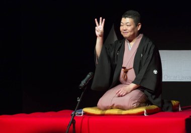 Kimliği belirsiz insanlar Japon tarzında tiyatro sahnesinde gösteri yapıyorlar.