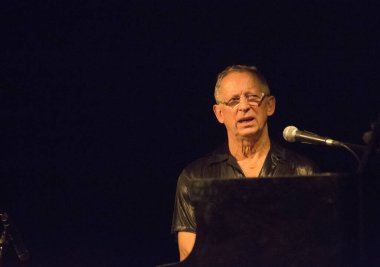 Kimliği belirsiz insanlar sahnede müzik yapıyor.