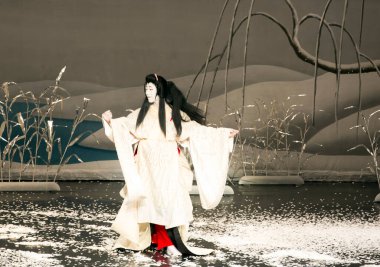 Kimliği belirsiz insanlar Japon tarzında tiyatro sahnelerinde oynuyorlar.