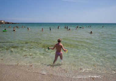 Kumsalda bikinili genç bir kadın.