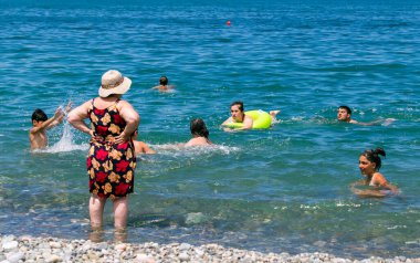 İnsanlar deniz kıyısında dinleniyor.