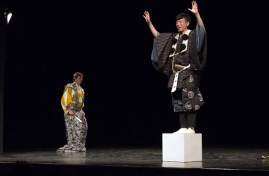 Kimliği belirsiz insanlar Japon tarzında tiyatro sahnelerinde oynuyorlar.