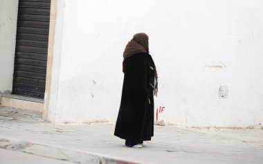 Siyah elbiseli, fularlı genç Müslüman kadın.