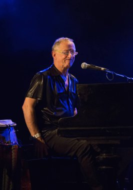 Kimliği belirsiz insanlar sahnede müzik yapıyor.