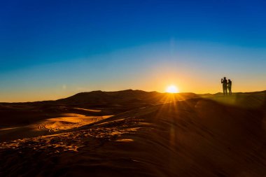 Merzouga, Fas - 29 Aralık 2017: İnsanlar Sahra Çölü, Güney Fas 'ta güneşin doğuşunu izliyor. 