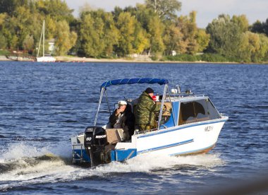 Genç bir adam kayıkta kürek çekiyor.