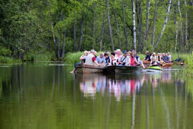 MASURIA, POLAND - 13 Temmuz 2012 'de tanımlanamayan insanlar Krutynia nehrinde kayak gezisine çıkarlar. Her yıl 5 milyondan fazla turist Masuria 'yı ziyaret ediyor.