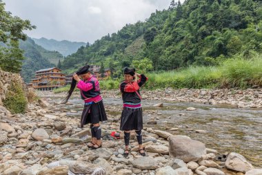 Dağlarda nehir kıyısında iki kadın.
