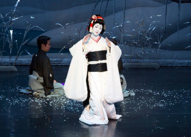 Kimliği belirsiz insanlar Japon tarzında tiyatro sahnelerinde oynuyorlar.