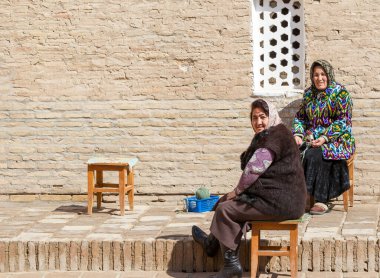 KHIVA, UZBEKISTAN - 21 Mart 2012 'de Özbekistan' ın başkenti Khiva 'da poz veren geleneksel bulutlu kadınlar. Özbekistan 'ın genişletilmiş bir turizm sektörü için büyük potansiyeli var.