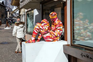 Şehirde renkli elbiseli bir adam var.