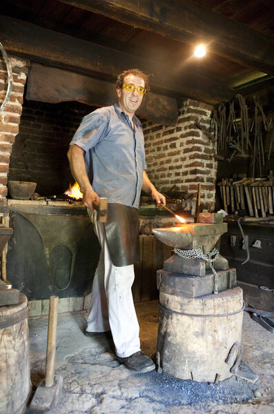 Человек, работающий кузнецом в мастерской