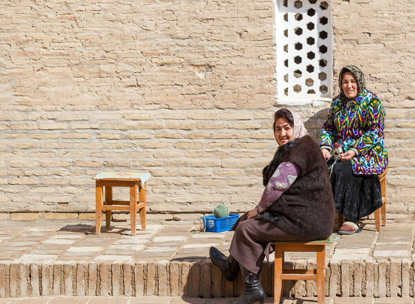 KHIVA, UZBEKISTAN - MARCH 21: Traditionally clouded women posing for tourist on March 21, 2012 in Khiva, Uzbekistan. Uzbekistan has great potential for an expanded tourism industry.