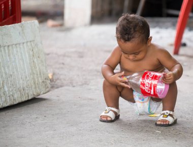 Küçük çocuk şişeyle oynuyor.