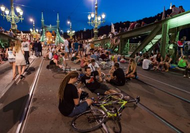 Budapeşte, Macaristan - 6 Temmuz 2019: Macar başkentinin en eski köprülerinden biri olan Liberty Köprüsü 'nde yaz gecesinin tadını çıkaran tanımlanamayan insanlar. Köprü hafta sonları ulaşıma kapatıldı. 