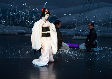 Kimliği belirsiz insanlar Japon tarzında tiyatro sahnelerinde oynuyorlar.