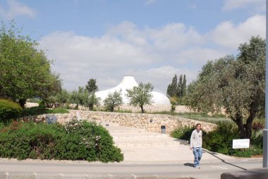 Sırt çantası ve şapkasıyla parkta genç bir kadın.