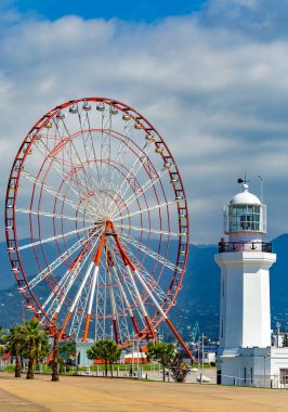 BATUMI, GEORGIA - 20 Temmuz 2015: Batumi 'de dönme dolap ve deniz feneri. 190.000 kişilik nüfusuyla Batumi önemli bir liman ve ticaret merkezi olarak hizmet vermektedir..