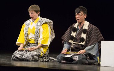 Kimliği belirsiz insanlar Japon tarzında tiyatro sahnelerinde oynuyorlar.