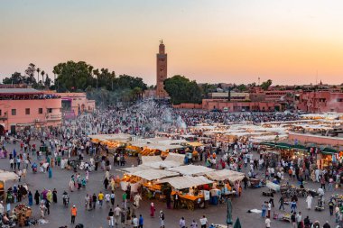 MARRAKESH, MOROCCO - JUNE 3: Unidentified people visit the Jemaa el Fna Square on June 3, 2013 in Marrakesh, Morocco. The square is part of the UNESCO World Heritage clipart