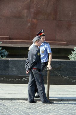 Silahlı, üniformalı genç bir adam.