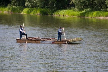 Nehirdeki ahşap teknede adamlar