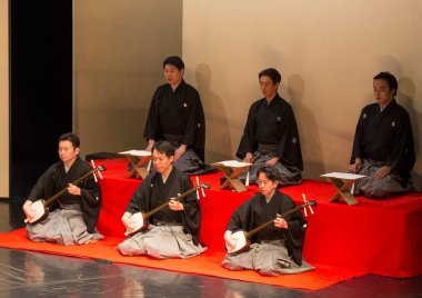 Kimliği belirsiz insanlar Japon tarzında tiyatro sahnelerinde oynuyorlar.