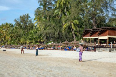 Tropik tatil beldesindeki plaj sandalyeleri ve palmiyeler