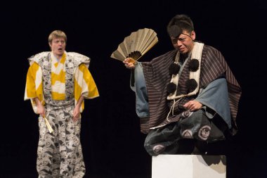 Kimliği belirsiz insanlar Japon tarzında tiyatro sahnelerinde oynuyorlar.