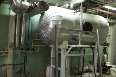 Vanaları ve kabloları olan endüstriyel kazan dairesi.