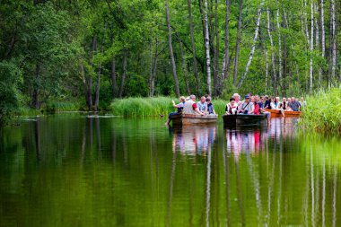 MASURIA, POLAND - 13 Temmuz 2012 'de kimliği belirlenemeyen insanlar, Poaland' ın Masurian bölgesindeki Krutynia nehrinde tekne gezisine çıkıyorlar. Her yıl 5 milyondan fazla turist Masuria 'yı ziyaret ediyor.
