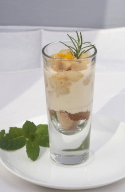 Bir bardak taze böğürtlen ve nane yapraklı yoğurt.