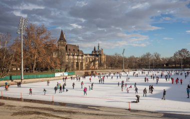 BUDAPEST, HUNGARY - 11 Aralık 2016: Macaristan 'ın Budapeşte kentindeki Ana Şehir Parkı' ndaki Vajdahunyad şatosunun önünde insanlar paten kayıyor.
