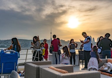 Bakü, Azerbaycan - 7 Mayıs 2019: Bakü, Azerbaycan 'da günbatımını izleyen insanlar.
