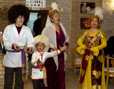 Geleneksel kostümlü insanlar Özbekistan, restoranda tatilde gösteri yapıyorlar