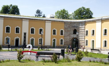 Bahçesi ve eski binanın yakınındaki patikaları olan güzel bir meydan.