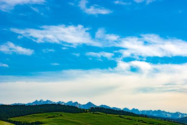 Mavi gökyüzü ve bulutlu dağ manzarası