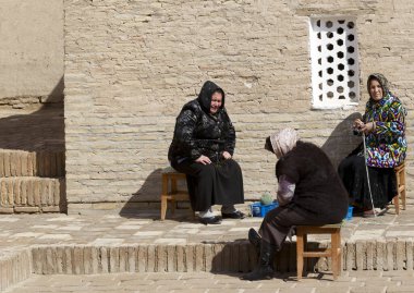 KHIVA, UZBEKISTAN - 21 Mart 2012 'de Özbekistan' ın başkenti Khiva 'da poz veren geleneksel bulutlu kadınlar. Özbekistan 'ın genişletilmiş bir turizm sektörü için büyük potansiyeli var.