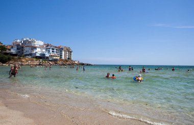 İnsanlar deniz sahilinde dinleniyor.