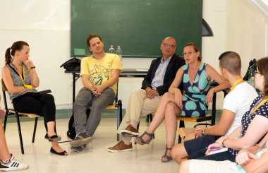 Sınıfta konuşan bir grup insan.
