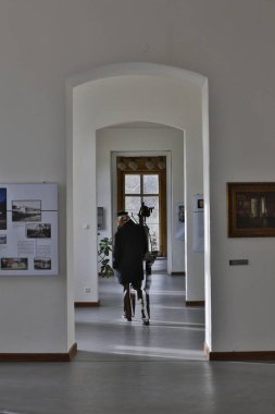 Siyah elbiseli, geniş pencereli bir kadın.