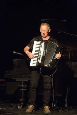 Kimliği belirsiz insanlar sahnede müzik yapıyor.