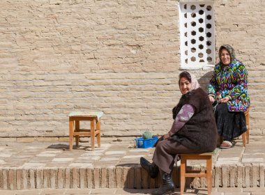 KHIVA, UZBEKISTAN - 21 Mart 2012 'de Özbekistan' ın başkenti Khiva 'da poz veren geleneksel bulutlu kadınlar. Özbekistan 'ın genişletilmiş bir turizm sektörü için büyük potansiyeli var.