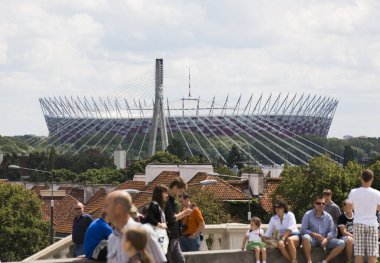 Polonya 'nın Varşova kentindeki futbol stadyumunun arka planındaki insanlar