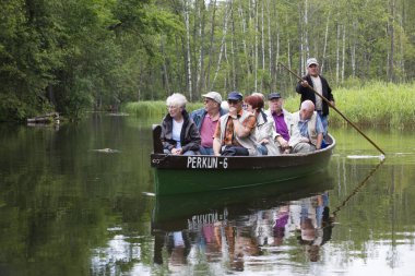 MASURIA, POLAND - 13 Temmuz 2012 'de kimliği belirlenemeyen insanlar Krutynia nehrinde kayak gezisine çıkarlar. Her yıl 5 milyondan fazla turist Masuria 'yı ziyaret ediyor.