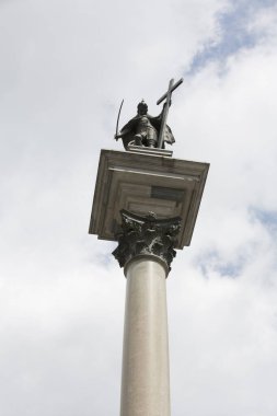 Bulutlu arkaplanda sütun üzerinde uzun heykel