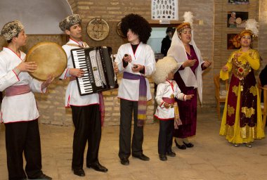 Geleneksel kostümlü insanlar Özbekistan, restoranda tatilde gösteri yapıyorlar