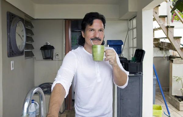 自宅で飲み物を飲むヒスパニック系の男 — ストック写真