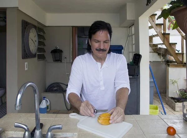 Hombre hispano cortando fruta estrella con cuchillo — Foto de Stock